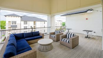 Balcony with couches and chairs and a table